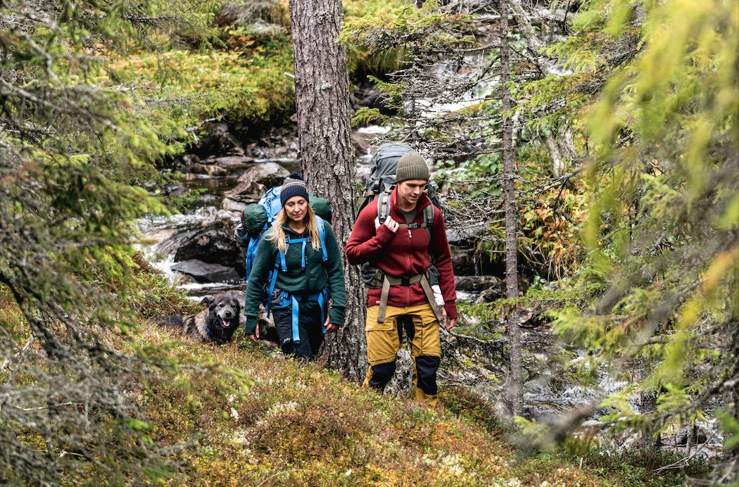 two people hiking through the forest Woolpower marken Shop